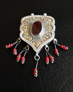 "⚠️🇩🇪 WE NO LONGER OFFER SHIPPING TO GERMANY! This is a rare collector piece estimated to be from 1940 - 1950. Extremely well crafted and well preserved Antique Ersary Turkoman stamped 925 sterling silver and Gold-wash pendant with focal oblong carnelian set in bezel and delicate coral dangles. Detailed repoussé throughout. A superb pendant to be added to your authentic collection of Turkmen Silver jewelry. Length: 3\" or 7.5 cm Width: 2\" or 5 cm Weight: 0.35 oz or 9.9 g This is a very well a Turkish Pendant Jewelry, Etruscan Jewelry Silver Pendant, Artisan Red Carved Jewelry, Traditional Brown Medallion Jewelry, Traditional Silver Carnelian Necklace, Traditional Handmade Carnelian Necklace, Traditional Silver Carnelian Jewelry, Traditional Red Jewelry For Collectible, Traditional Red Jewelry For Collectors