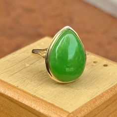 Estate 14KT Yellow Gold Teardrop Pear Jade Large Green Bezel Set Band Ring Beautiful, vibrant, dyed green jade!  Size 7 Weight: 3.73 grams Band width: 2mm Genuine jade measures: 20mm x15mm stamped 14KT  Excellent estate condition This is a great ring. Unique, well made Please take a look at our other jewelry items. Thank You, Legacy Saint Jewelry -OUR RETURN POLICY-  To return an item you must first contact us within 7 days of receiving your item(s). Upon messaging us we will provide the steps in returning or exchanging. The buyer is fully responsible for paying for return shipping. We offer refunds minus $10 or 10% of the item cost (plus any mandatory taxes), whichever is greater will be subtracted from the refunded amount. Your refund will post back to you within 7 business days of recei Green Teardrop Ring For May Birthstone, Teardrop Green May Birthstone Ring, Green Teardrop May Birthstone Ring, Fine Jewelry Green Pear-shaped Ring, Green Teardrop Fine Jewelry Ring, Green Teardrop Emerald Ring For May Birthstone, Classic Green Teardrop Emerald Ring, Green Pear-shaped Emerald Gemstone Ring, Classic Green Drop Jewelry