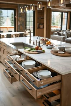 an open drawer in the middle of a kitchen island with plates and bowls on it