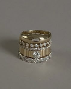 a gold ring with three rows of diamonds on top and two bands around the band