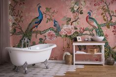 a bathtub sitting in front of a wall with flowers and peacocks on it