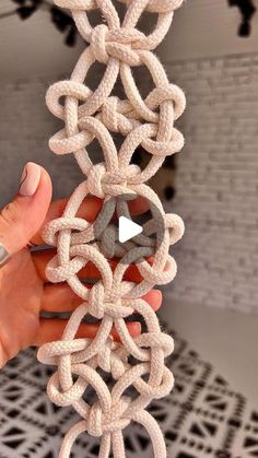 a person holding up a piece of rope with an object in the middle of it