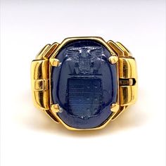 A truly remarkable reversible sapphire carved signet ring in 18 karat yellow gold, circa 1940. This unusual and ingeniously crafted ring comprises of a deep blue cabochon sapphire, engraved with a seal to one side with a smooth polished cabochon dome to the other. The wearer can choose to either wear the sapphire on its smooth polished dome or by using its clever integrated side release mechanism to flip over the sapphire to reveal its seal engraving. This ring really has an impressive wow facto Luxury Sapphire Signet Ring As Promise Ring, Formal Gold Cabochon Signet Ring, Antique Signet Ring With 17 Jewels For Formal Occasions, Vintage Engraved Sapphire Ring For Formal Occasions, Antique Embellished Signet Ring For Formal Occasions, Gold Engraved Sapphire Ring For Formal Occasions, Antique Gold Sapphire Ring Stamped 14k, Vintage Gold Sapphire Ring Stamped 14k, Antique Style Polished Sapphire Ring For Formal Occasions