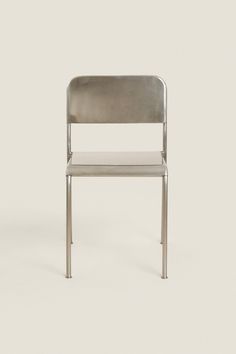 a silver chair sitting on top of a white floor