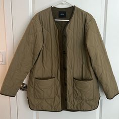 Very Good Condition; Small Stain On Sleeve, Barely Noticable, Doesnt Look Like Oil So Would Come Out In Wash. The Perfect Layering Piece For On The Go And Over A Cozy Sweater. This Oversized Quilted Nylon Jacket Features Contrast Coloring At The Placket And Cuffs With Horn Button Detailing. 100%Polyester. Imported. Recommend Ordering True To Size. Front Body Length: 30 5/8" Khaki Long Sleeve Utility Jacket With Double-lined Hood, Green Quilted Long-sleeve Outerwear, Military Khaki Outerwear With Fleece Lining, Green Puffer, Khaki Military Outerwear With Button Closure, Nylon Quilted Jacket With Double-lined Hood, Jacket Buttons, Puffer Coat, Cozy Sweaters