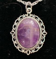 Very nice looking,.  Amethyst is one of the most famous and prominent crystals because of its beautiful coloration as well as its spiritual and literal meaning.  The spiritual meaning of Amethyst is groundedness, tranquility, and calm. The literal meaning of Amethyst is "not intoxicated".  To this ancient, wise culture, the Amethyst crystal was of the utmost importance, and the myth associated with it still lives on inside it to this day.  You can immediately feel peace of mind by simply looking at this brilliant crystal. In fact, its radiant purple and white colors have represented the sobriety of emotions and spirit throughout history.  It is also the traditional gift for a couple's 33rd wedding anniversary because 33 is the number of divine protection. Stone Size: 18x13 mm.   USPS First Oval Necklace With Large Stone For Gifts, Gift Necklace With Large Oval Stone, Purple Gemstone Oval Pendant Necklace, Purple Gemstone Necklace With Oval Pendant, Spiritual Purple Necklace With Large Stone, Oval Pendant Necklace With Large Stone For Gift, Large Stone Oval Pendant Necklace For Gifts, Purple Oval Stones Jewelry, Purple Oval Gemstone Necklace