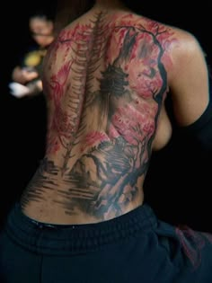 the back of a woman's body covered in tattoos