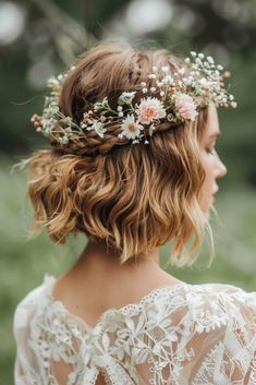 a woman with flowers in her hair wearing a white lace dress and a flower crown