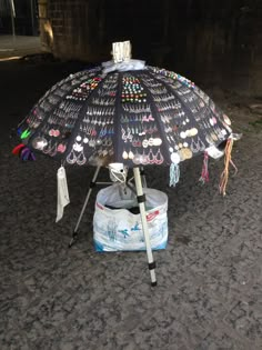 an umbrella that has been decorated with many different things on it and is sitting on the ground