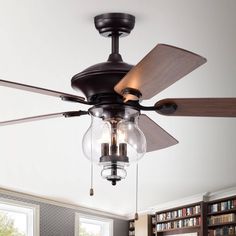 a ceiling fan that is hanging from the ceiling in a room with bookshelves