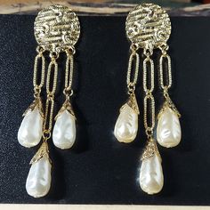 E1719 Dramatic Gold & Pearl Teardrop Statement Earrings Aprox 4" Drop Post Back Goldtone Stoppers Bundle & Save! Join The Live Shows! Automatically Save 25% On 3+! Buy With Confidence! 1000+ Listings Available! New Items Added Weekly! Party Cohost, Posh Ambassador & Mentor With 3000+ Sales! #Jesisfashionz #Statement #Jewelry #Fun #Fashion #Fashionjewelry #Style #Gunmetal #Statementearrings #Chunky #Funky #Diva #Largeearrings #Runway #Boutique #Ear #Accessories #Accessory #Different #Glam #Model White Metal Clip-on Pearl Earrings, White Clip-on Metal Pearl Earrings, Clip-on White Pearl Earrings, White Metal Pearl Drop Clip-on Earrings, White Metal Clip-on Earrings With Pearl Drop, Elegant White Metal Chandelier Earrings, Vintage White Chandelier Earrings For Party, White Metal Dangle Bridal Earrings, Metal Pearl Drop Teardrop Earrings For Party