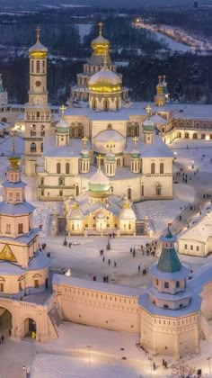 an aerial view of a large church in the middle of a snow covered field at night