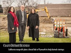 three people standing next to each other in front of construction equipment