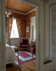 an open door leading to a bedroom with wooden walls