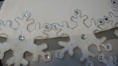 snowflakes on white fabric with silver sequins in the middle and one being cut out