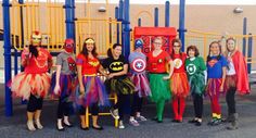 a group of people standing next to each other near a play structure with costumes on