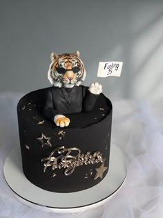 a cake with a tiger sitting on top of it and a sign in the middle