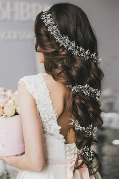 a woman in a wedding dress holding a pink cake