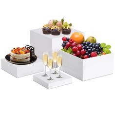 three white boxes filled with different types of desserts and champagne glasses on top of each box