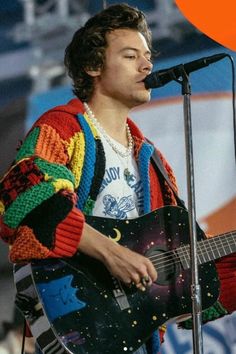 a young man is playing the guitar on stage