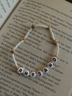 a beaded bracelet with the word hysa spelled in white beads on an open book