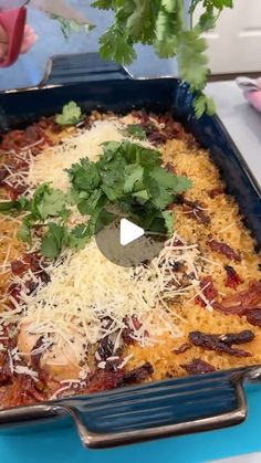 a casserole dish with meat, cheese and cilantro on the side