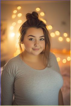 a woman is smiling and posing for the camera with lights in the back ground behind her