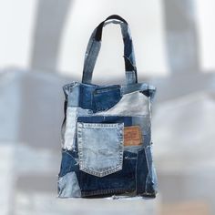 A raw-looking Crazy Quilt Tote Bag with a Levi's patch in a unique design made out of reused denim. It has black cotton lining. The bag has one pocket on the outside, ond small zipped pocket on the inside and one detachable pocket that you can hang either on the inside or outside. The detachable pocket has a zipper (from a pair of jeans) and will make it a lot easier for you to find e.g. your cellphone or money. You can also use the detachable pocket on its own.  The approx. measurements of the Upcycled Recycled Denim Tote Shoulder Bag, Upcycled Recycled Denim Shoulder Bag, Upcycled Shoulder Bag In Recycled Denim, Everyday Recycled Denim Tote Bag, Upcycled Cotton Tote Shoulder Bag, Upcycled Rectangular Denim Bag, Upcycled Rectangular Recycled Denim Bag, Rectangular Upcycled Recycled Denim Bag, Recycled Denim Tote Shoulder Bag With Pockets