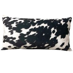 a black and white cow print pillow on a white background