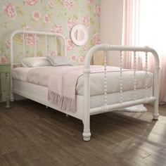 a white bed sitting on top of a wooden floor