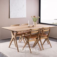 a dining table with four chairs and a vase filled with flowers sitting on top of it