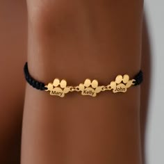 a woman wearing a gold bracelet with four paw prints on it and the words mary, kelly