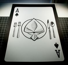 an ace playing card with forks and spoons