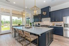 a large kitchen with blue cabinets and marble counter tops