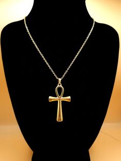 Discover the timeless elegance of our Ankh Pendant Necklace, a stunning piece of jewelry that transcends style boundaries. Expertly crafted with an 18k gold plating, this unisex necklace embodies the rich heritage of Ancient Egypt, featuring the iconic Ankh - the Key of Life. Made from hypoallergenic, tarnish-free 304 stainless steel, this necklace ensures comfort and longevity for even the most sensitive skin. The gold finish provides a luxurious touch, while its waterproof design guarantees du Luxury Yellow Gold Ankh Necklace, Spiritual Cross Pendant Clavicle Chain, Spiritual Clavicle Chain With Cross Pendant, Classic Jewelry With Large Pendant As A Gift, Classic Cross Jewelry With Adjustable Chain, Spiritual Clavicle Chain Cross Jewelry, Elegant Brass Cross Pendant Necklace, Gold Ankh Brass Jewelry, Amulet Style Ankh Necklace In Brass