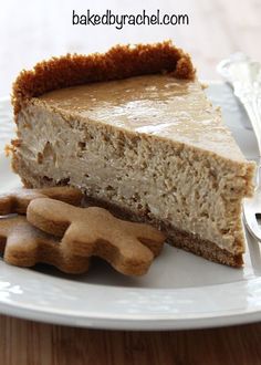 a piece of cheesecake on a plate with some cookies and a fork next to it