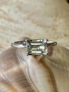 This classic East West solitaire setting contains a beautiful 2.00ct genuine prasiolite. The emerald cut stone measures approximately 8x6mm. The ring is available in sterling silver, and 14k white, yellow, or rose gold. This ring makes a great promise or engagement ring. Please send me a message if you need a size not listed. * This ring can be customized with any color center stone. All items are handmade by me in my shop in Woodbridge, NJ. Please message me with any questions. Shipping within Classic Emerald-cut Topaz Ring In Sterling Silver, Classic Emerald Cut Crystal Ring As Gift, Classic Emerald Cut Crystal Ring For Gift, Timeless Emerald Cut Topaz Ring With Prong Setting, Timeless Emerald-cut Topaz Ring With Prong Setting, Classic Emerald Cut Ring With Ethically Sourced Gemstones, Classic Silver Topaz Baguette Cut Ring, Emerald Cut Sapphire Solitaire Promise Ring, Classic Emerald Cut Topaz Ring With Prong Setting