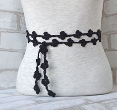 a black crocheted belt with flowers on it