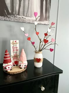 two small vases with hearts on them are sitting on a table next to a card holder