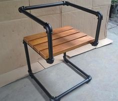 a wooden chair sitting on top of a metal frame next to a brick wall and cement floor