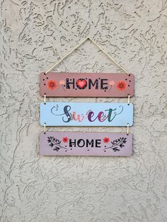 three wooden signs hanging on the side of a wall with words home sweet and home