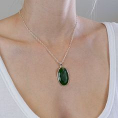 The darker greens in this Nephrite Jade necklace give you more freedom to express yourself. It's a simple neutral gemstone necklace that will brighten your day when paired with other gems. It's all about harmonizing energy with this old, precious crystal necklace. Stone Origin: New Zealand Measures Approximately: 35 x 22 mm Materials: Hand Crafted 925 Polished Sterling Silver and adjustable Italian Belcher chain Please Note: If you would like to purchase a different chain please purchase pendant Green Oval Pendant Necklace For Spiritual Style, Green Oval Pendant Necklace Spiritual Style, Spiritual Green Oval Pendant Necklace, Green Oval Necklace With Large Stone, Oval Green Necklace With Large Stone, Jade Oval Pendant Necklace With Natural Stones, Jade Necklace With Oval Pendant And Natural Stones, Green Necklace With Oval Pendant And Natural Stones, Green Oval Pendant Necklace With Natural Stones