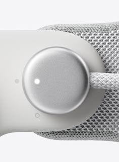 the back end of an apple watch with a white strap and silver button on it