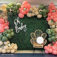 a backdrop made out of balloons and greenery for a baby's first birthday