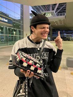 a young man is smiling while holding a toy in his hand and pointing to the side