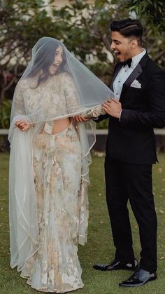 a man in a tuxedo standing next to a woman wearing a wedding veil