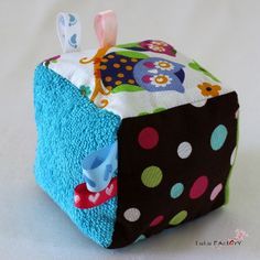 a close up of a small toy on a white surface with polka dots and an owl