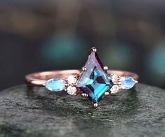 Introducing the enchanting Vintage Marquise Kite Cut Alexandrite Moonstone Engagement Ring Set, a true testament to the timeless beauty of gemstones and the artistry of vintage design. This set is a captivating blend of elegance and mystique, making it the perfect choice for a couple who appreciates the rare and the extraordinary. Ring set comes with the engagement ring and band. The main stone is a 6x9mm kite cut Lab Alexandrite. The accent stones are round 1.5mm and marquise 2x4mm moonstones.B Kite Cut Ring, Gemstone Jewelry Earrings, Moonstone Engagement Ring Set, Ring Rosegold, Diamond Crown, Alexandrite Engagement Ring, Moonstone Engagement, Moonstone Engagement Ring, Ring Rose Gold