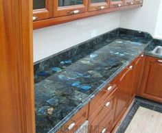 a kitchen with wooden cabinets and marble counter tops