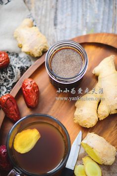 a wooden plate topped with sliced up bananas next to a cup of tea and spices